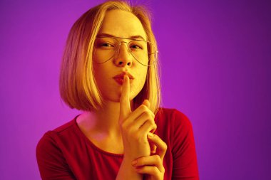 Sessizlik için neon arka plan üzerinde arama genç kadın