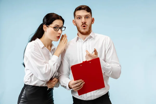 De verrast zakenman en -vrouw die lacht op een grijze achtergrond — Stockfoto