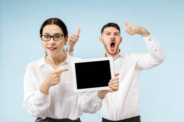 Sürpriz iş adamı ve gri bir arka plan üzerinde gülümseyen kadın