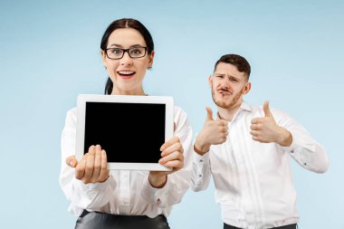 Sürpriz iş adamı ve gri bir arka plan üzerinde gülümseyen kadın