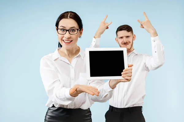 Der überraschte Geschäftsmann und die Frau lächeln auf grauem Hintergrund — Stockfoto