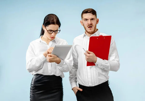 El hombre y la mujer de negocios sorprendidos sonriendo sobre un fondo gris — Foto de Stock