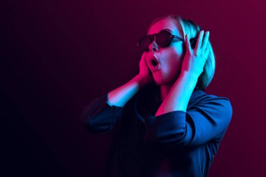 Neon arka plan üzerinde müzik kulaklık ile güzel kadın moda