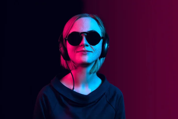 Neon arka plan üzerinde müzik kulaklık ile güzel kadın moda — Stok fotoğraf