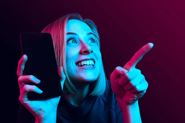 Porträtt av en säker casual flicka visar blank skärm mobiltelefon isolerade över Blå bakgrund — Stockfoto