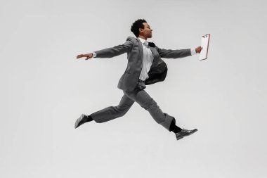 Happy businessman dancing isolated on gray studio background clipart