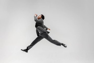 Beyaz stüdyo arka plan üzerinde izole hareket dans mutlu iş adamı. Esneklik ve zarafet içinde iş. İnsan duyguları kavramı. Office, başarı, profesyonel, mutluluk, ifade kavramları