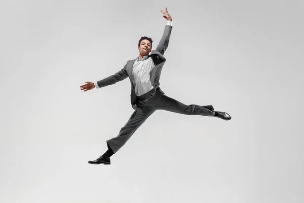 Happy businessman dancing isolated on gray studio background Stock Image