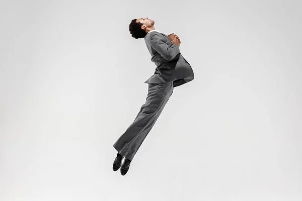 Happy businessman dancing isolated on gray studio background Stock Image