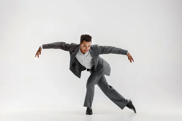 Happy businessman dancing isolated on gray studio background Royalty Free Stock Images