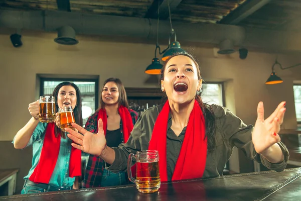 Concept de sport, de personnes, de loisirs, d'amitié et de divertissement - fans de football heureux ou amies buvant de la bière et célébrant la victoire au bar ou au pub — Photo