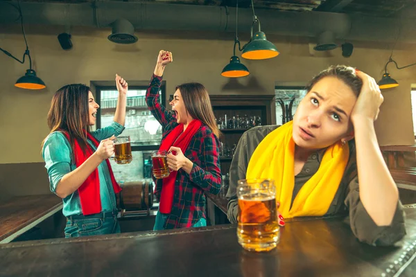 Deporte, gente, ocio, amistad y entretenimiento: aficionados al fútbol felices o amigas bebiendo cerveza y celebrando la victoria en el bar o pub — Foto de Stock