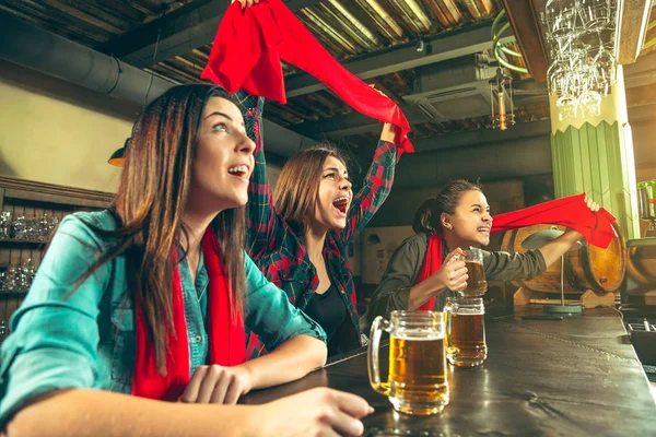 Concept de sport, de personnes, de loisirs, d'amitié et de divertissement - fans de football heureux ou amies buvant de la bière et célébrant la victoire au bar ou au pub — Photo