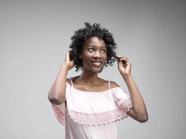 Wanita afrika yang bahagia berdiri dan tersenyum dengan latar belakang merah . — Stok Foto