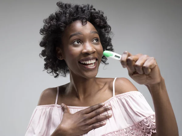 Sorridente giovane donna in cerca di test di gravidanza — Foto Stock