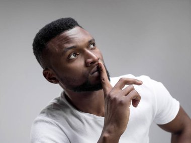 Ciddi korkmuş erkek ön plana tutan parmak dudaklarında