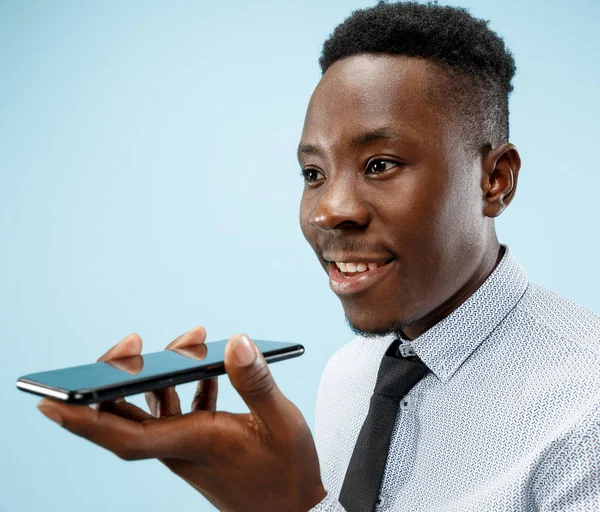 Innenporträt eines attraktiven jungen schwarzen Mannes mit leerem Smartphone — Stockfoto