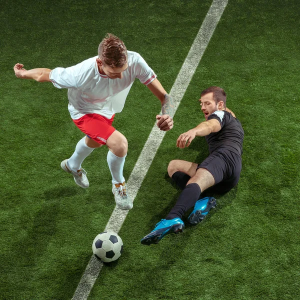 Jugadores de fútbol abordando pelota sobre fondo de hierba verde — Foto de Stock