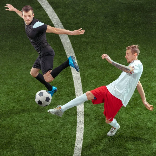 Football players tackling ball over green grass background