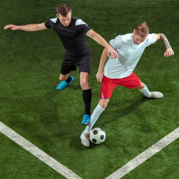 緑の草の背景の上ボールに取り組むサッカー選手 — ストック写真