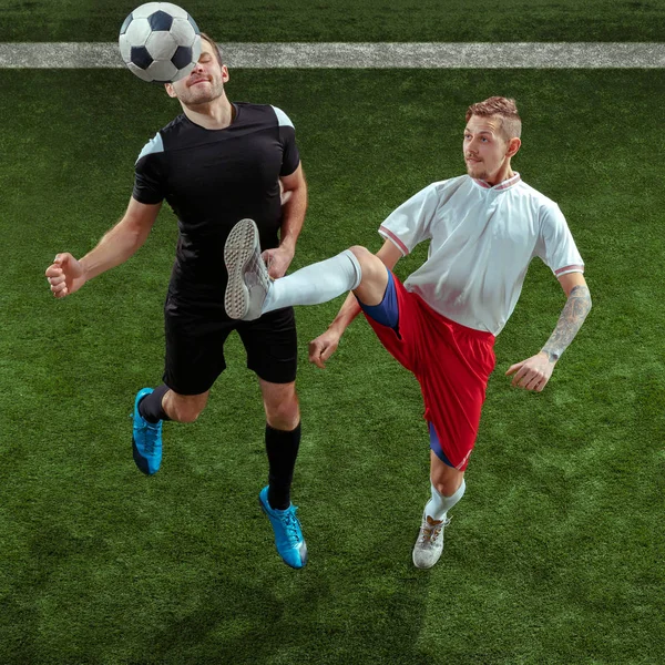 緑の草の背景の上ボールに取り組むサッカー選手 — ストック写真