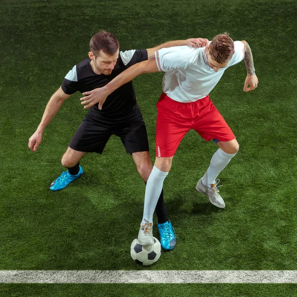 Jogadores de futebol atacando bola sobre fundo grama verde — Fotografia de Stock