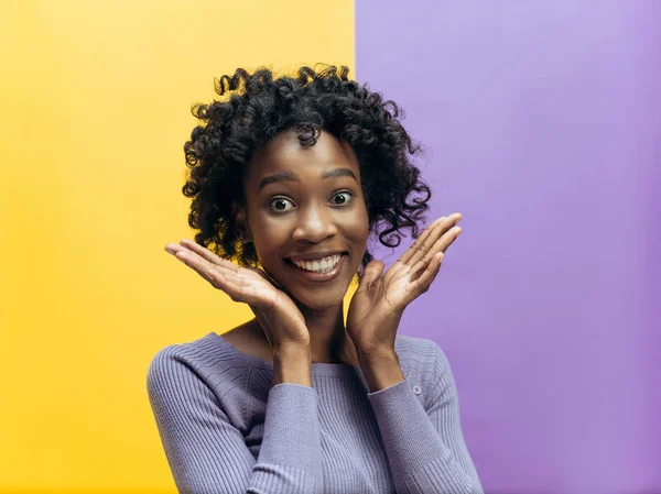 A mulher africana feliz de pé e sorrindo contra fundo cinza . — Fotografia de Stock