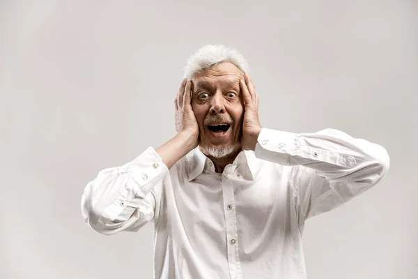 El hombre mayor mirando sorprendido aislado en gris — Foto de Stock