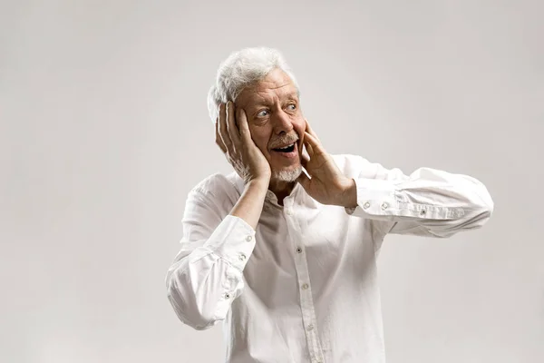 El hombre mayor mirando sorprendido aislado en gris — Foto de Stock
