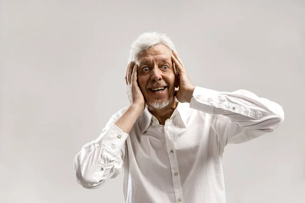 El hombre mayor mirando sorprendido aislado en gris — Foto de Stock