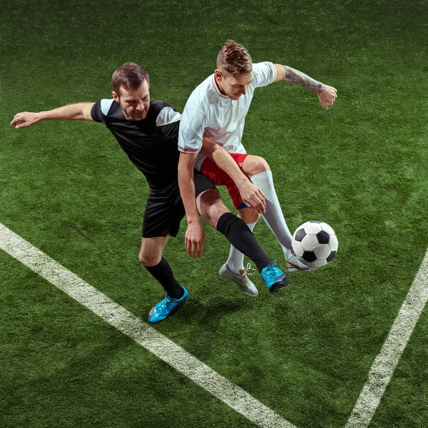 Футболисты играют в мяч на зеленом фоне травы — стоковое фото