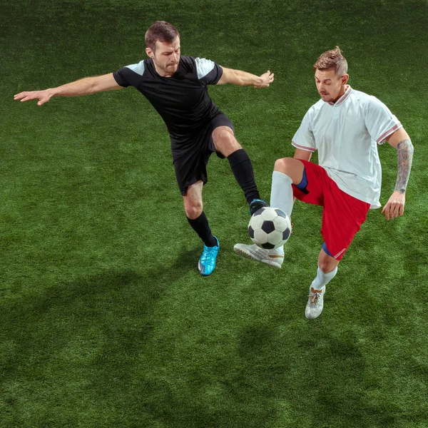 Ποδόσφαιρο παίκτες αντιμετώπιση μπάλα πάνω από το φόντο πράσινο γρασίδι — Φωτογραφία Αρχείου