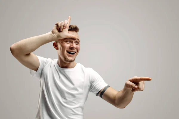 Os falhados vão para casa. Retrato de cara feliz mostrando sinal perdedor sobre a testa — Fotografia de Stock