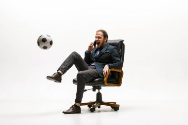 Ofisinde futbol topu olan bir iş adamı.