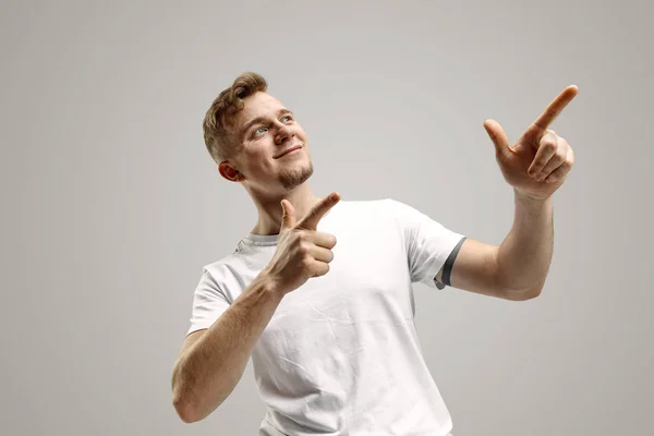 Stylish handsome young man pointing at studio — Stock Photo, Image