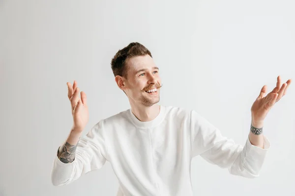 El hombre de negocios feliz de pie y sonriendo contra el fondo gris . —  Fotos de Stock