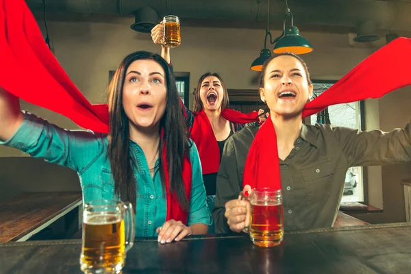 Deporte, gente, ocio, amistad y entretenimiento: aficionados al fútbol felices o amigas bebiendo cerveza y celebrando la victoria en el bar o pub — Foto de Stock