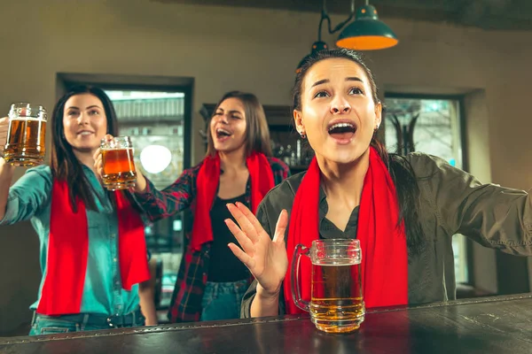 Deporte, gente, ocio, amistad y entretenimiento: aficionados al fútbol felices o amigas bebiendo cerveza y celebrando la victoria en el bar o pub — Foto de Stock