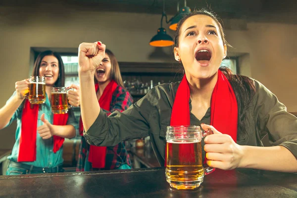 Concept de sport, de personnes, de loisirs, d'amitié et de divertissement - fans de football heureux ou amies buvant de la bière et célébrant la victoire au bar ou au pub — Photo