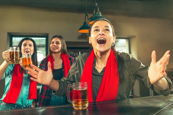 Deporte, gente, ocio, amistad y entretenimiento: aficionados al fútbol felices o amigas bebiendo cerveza y celebrando la victoria en el bar o pub — Foto de Stock