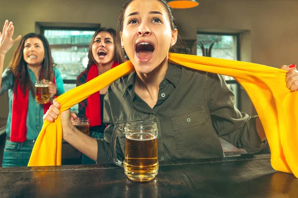 Concept de sport, de personnes, de loisirs, d'amitié et de divertissement - fans de football heureux ou amies buvant de la bière et célébrant la victoire au bar ou au pub — Photo