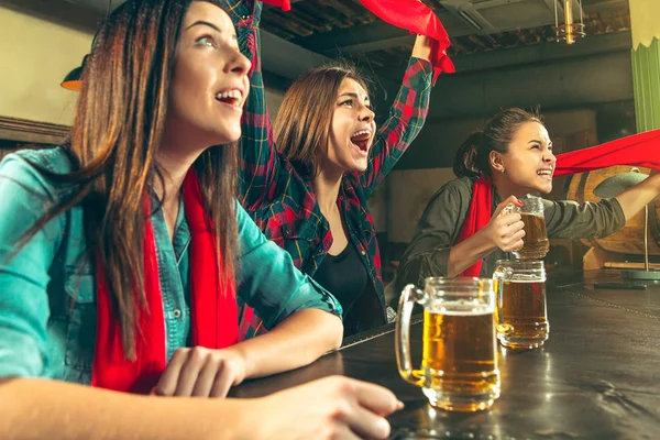 Sport, mensen, vrije tijd, vriendschap en entertainment concept - gelukkig voetbalfans of vriendinnen drinken bier en vieren overwinning bij bar of pub — Stockfoto