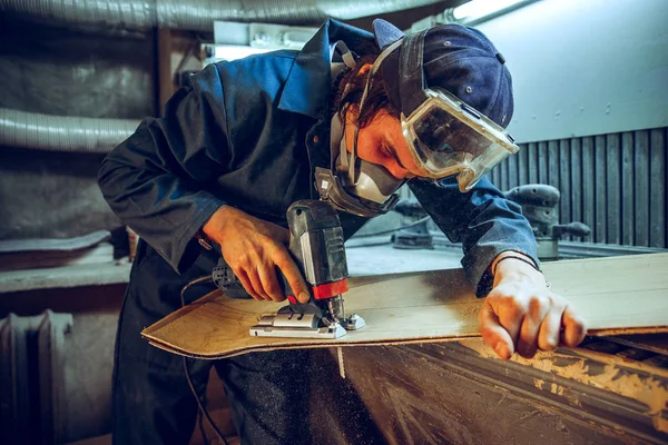 Carpinteiro com serra circular para cortar tábuas de madeira . — Fotografia de Stock