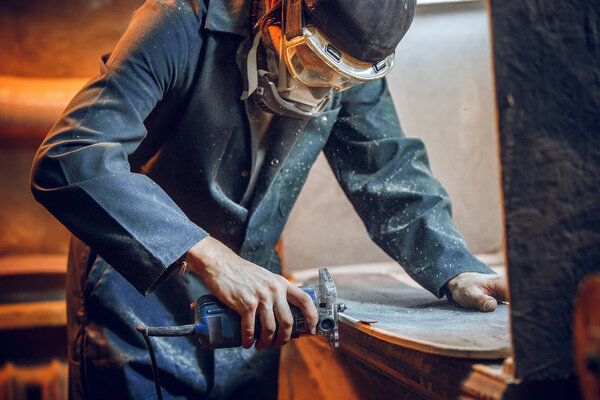 Carpenter using circular saw for cutting wooden boards.