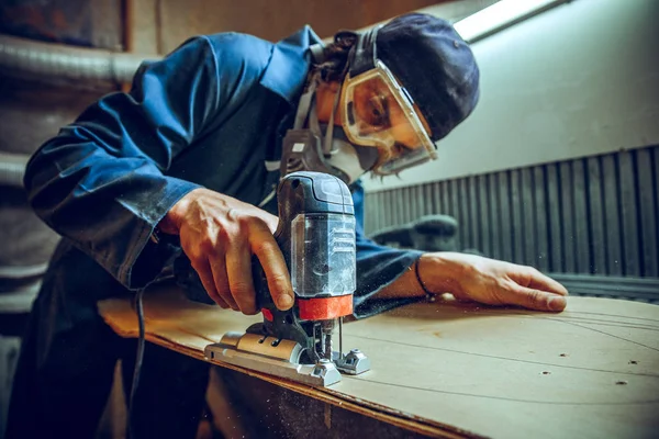 Carpenter using circular saw for cutting wooden boards. — Stock Photo, Image