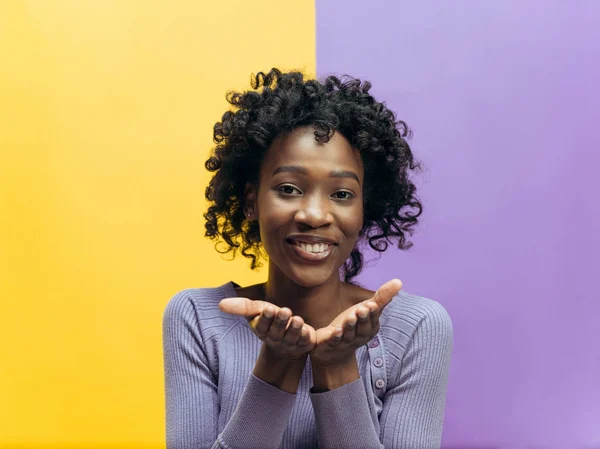 A mulher africana feliz de pé e sorrindo contra fundo de cor . — Fotografia de Stock