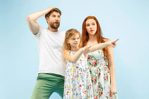 Glückliche Eltern mit Tochter im Studio isoliert auf blauem Hintergrund — Stockfoto