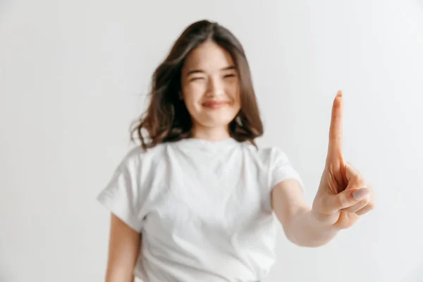 Mano de mujer con dedo sobre fondo gris —  Fotos de Stock