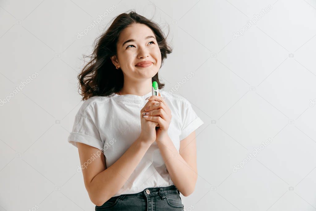 Smiling young woman looking on pregnancy test