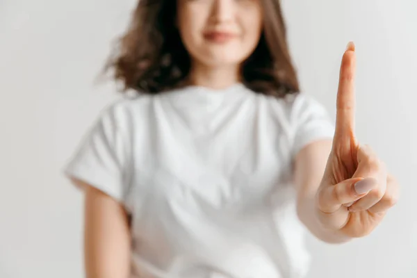 Mano de mujer con dedo sobre fondo gris —  Fotos de Stock